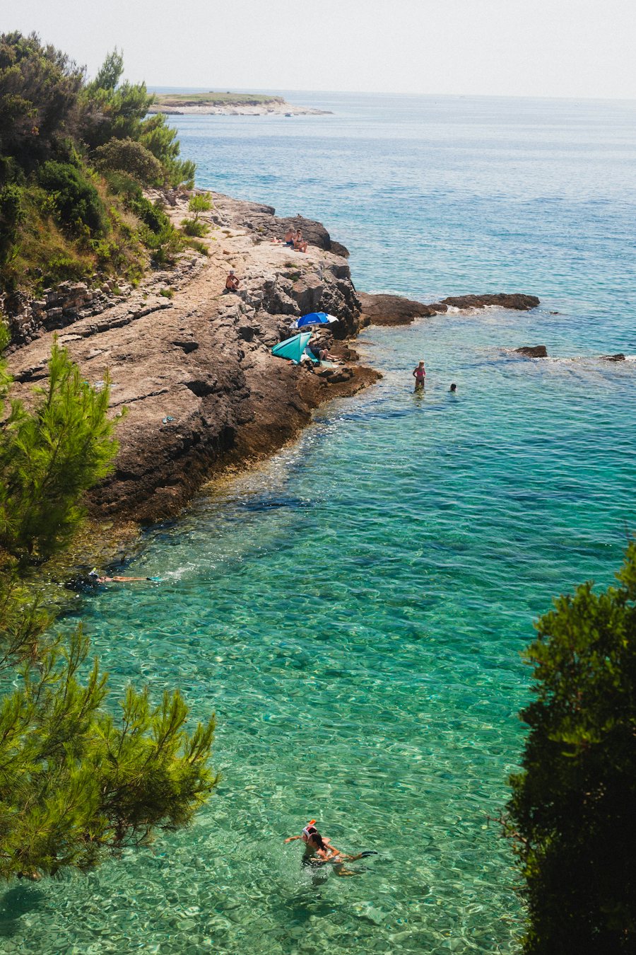 Gente bañándose en una cala turquesa