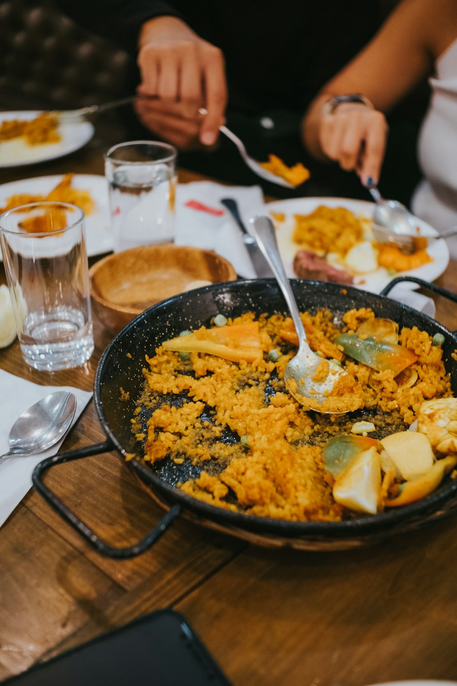 Arroz en paellera sobre una mesa de madera
